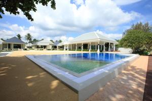 a swimming pool in front of a white building at Wis Beach Khanom in Khanom
