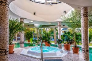 a hot tub in a room with plants at Residence Hotel Balaton in Siófok