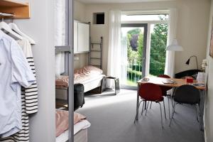 a bedroom with a bed and a desk and a table at Danhostel Kolding in Kolding