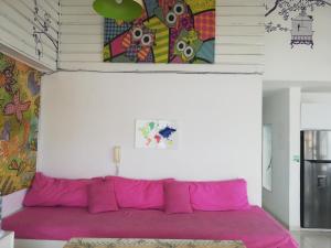 ein rosafarbenes Sofa in einem Zimmer mit einem Gemälde an der Wand in der Unterkunft Edificio Santa Catalina 602 in San Andrés