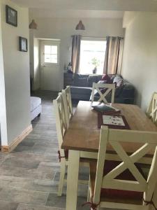 uma sala de estar com uma mesa de jantar e um sofá em Ash Lodge Leitrim Village em Leitrim