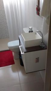 ein weißes Badezimmer mit Waschbecken und Toilette in der Unterkunft Repouso Clave de Sol in Paraty