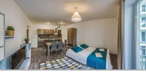 - une chambre avec un lit et une salle à manger dans l'établissement Nova City Apartments, à Budapest