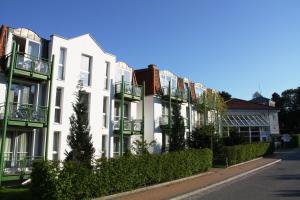 un edificio bianco con balconi sul lato di una strada di Aparthotel Tropenhaus Bansin a Bansin