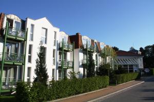 バンシンにあるAparthotel Tropenhaus Bansinの通り沿いにバルコニーがある白い建物