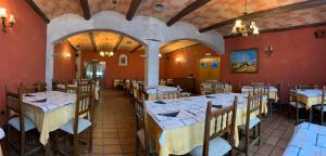 un restaurante con mesas y sillas en una sala con paredes rojas en Hostal Monasterio de Rueda, en Sástago