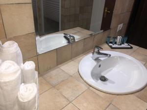 a bathroom with a white sink and a tub at Aquila Di Mare in Fiumicino