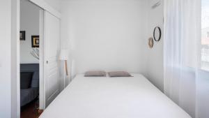 1 dormitorio con 1 cama blanca en una habitación blanca en Le Marengo: Charmant, Rénové, Terrasse, Parking privé en Toulouse