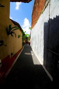 a narrow alley with a building and a wall at Latugu Homestay Ubud in Ubud