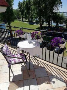 stół i krzesło na balkonie z kwiatami w obiekcie Pensjonacik Grażyna w mieście Ełk