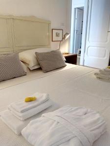 - deux serviettes au-dessus d'un lit blanc dans l'établissement Casa vacanze "Borahall", à Trieste