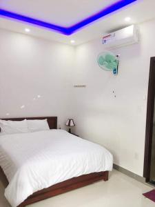 a bedroom with a white bed with a blue ceiling at Motel Thanh Long in Da Nang
