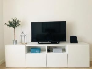 A television and/or entertainment center at Moderno apartamento, central e confortável