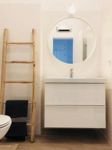 ein Badezimmer mit einem Waschbecken, einem Spiegel und einer Leiter in der Unterkunft Moderno apartamento, central e confortável in Montijo