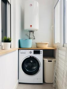 a washing machine in a kitchen with a counter at Moderno apartamento, central e confortável in Montijo