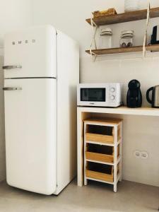 a kitchen with a white refrigerator and a microwave at Moderno apartamento, central e confortável in Montijo