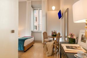 um quarto de hotel com uma cama, uma secretária e uma mesa em Boutique Hotel Atelier '800 em Roma