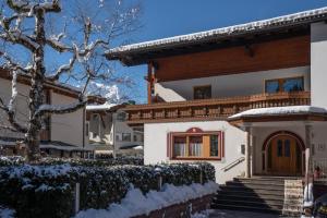 une maison dans la neige avec une clôture dans l'établissement Apartment Mozart, à Mayrhofen