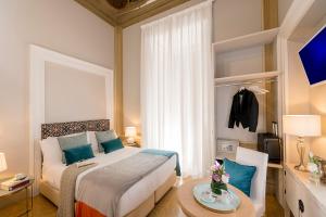 ein Schlafzimmer mit einem Bett und einem Tisch in einem Zimmer in der Unterkunft Boutique Hotel Atelier '800 in Rom