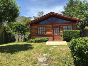 una cabaña de madera en un patio con césped en Cabañas del Alba en Lago Puelo