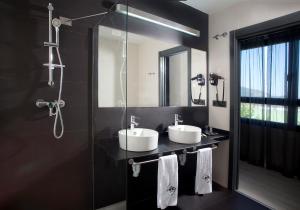Baño negro con 2 lavabos y ducha en Hotel K10, en Urnieta