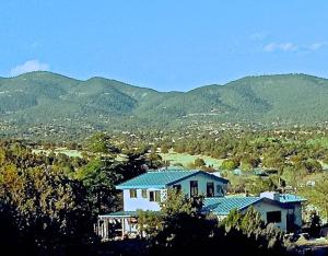 una casa su una collina con montagne sullo sfondo di Heart and Wings Retreat Center a Silver City