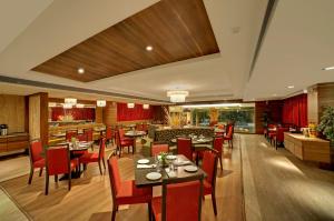 a restaurant with tables and chairs and a bar at Ramada Ahmedabad in Ahmedabad
