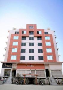 een hoog rood-wit gebouw met een balkon bij Mayur Residency Hotel in Guwahati