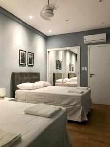 1 dormitorio con 2 camas y un espejo grande en Apartamento 2 quartos, padrão hotel na Avenida Paulista, en São Paulo