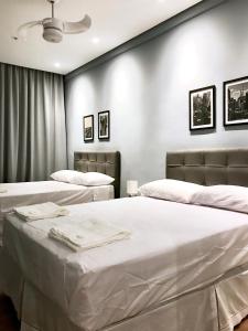2 camas en una habitación con sábanas blancas en Apartamento 2 quartos, padrão hotel na Avenida Paulista, en São Paulo