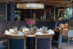a dining room with a table with a vase of flowers at Holmen Fjordhotell in Nesbru