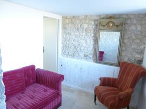 a living room with a pink couch and two chairs at AU NID DES VIGNES in Cahuzac-sur-Vère