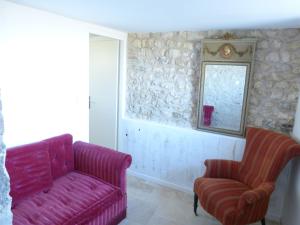 Cahuzac-sur-VèreにあるAU NID DES VIGNESのリビングルーム(ピンクのソファ、椅子2脚付)