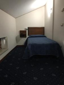 een slaapkamer met een bed met een blauwe deken bij Hotel Civita in Avellino