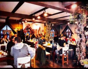 a group of people sitting at tables in a restaurant at Royal Village Kotromanićevo in Vranduk