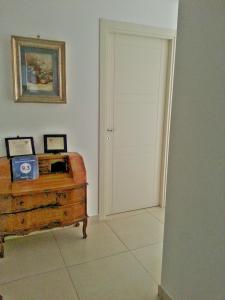 Habitación con puerta blanca y cofre de madera. en Antares Bed and Breakfast, en Siracusa