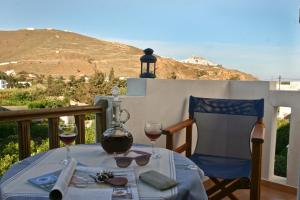 Livadi AstypalaiasにあるEsperisのバルコニーにテーブルとワイン2杯