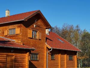 uma casa de madeira com um telhado vermelho em Villa Kazaw em Kaszó