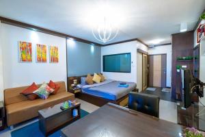 ARMO Nimman في شيانغ ماي: غرفة معيشة مع أريكة وسرير
