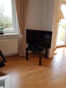 a living room with a flat screen tv on a table at Nordseeblick Ferienhaus in Wobbenbüll