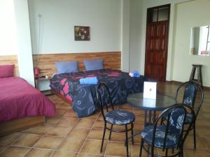 una camera da letto con un letto, un tavolo e delle sedie di Hotel Kurtabeg a Shkodër