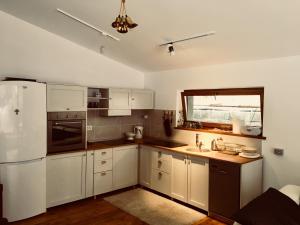 a kitchen with white cabinets and a white refrigerator at SOHO Lodge Rasnov in Râşnov
