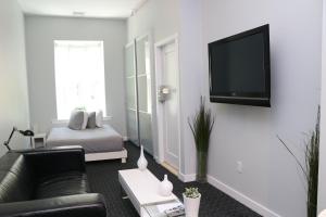 a living room with a couch and a tv on a wall at Stylish Newbury Street Studio, #11 in Boston