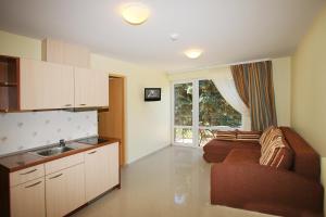 a kitchen and living room with a couch and a window at Vila Medus in Palanga