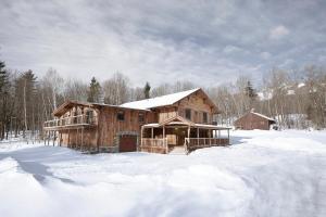 uma grande cabana de madeira na neve com neve em Seesaw's Lodge em Peru
