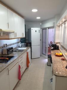 a kitchen with white cabinets and a white refrigerator at Amazing Condo in Alicante City Center in Alicante