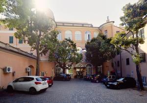 un gran edificio con coches estacionados frente a él en Hotel Mediterranee en Génova
