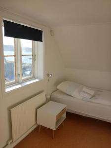 
En eller flere senge i et værelse på Café de Upernavik
