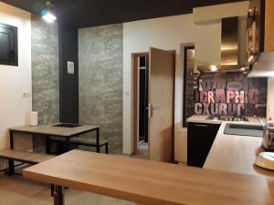 une cuisine avec deux tables et un comptoir dans l'établissement Joli 2 pièces esprit loft moderne, à Pau