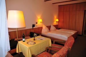 ein Hotelzimmer mit einem Bett und einem Tisch mit einer Lampe in der Unterkunft WAGNERS Hotel im Fichtelgebirge in Warmensteinach